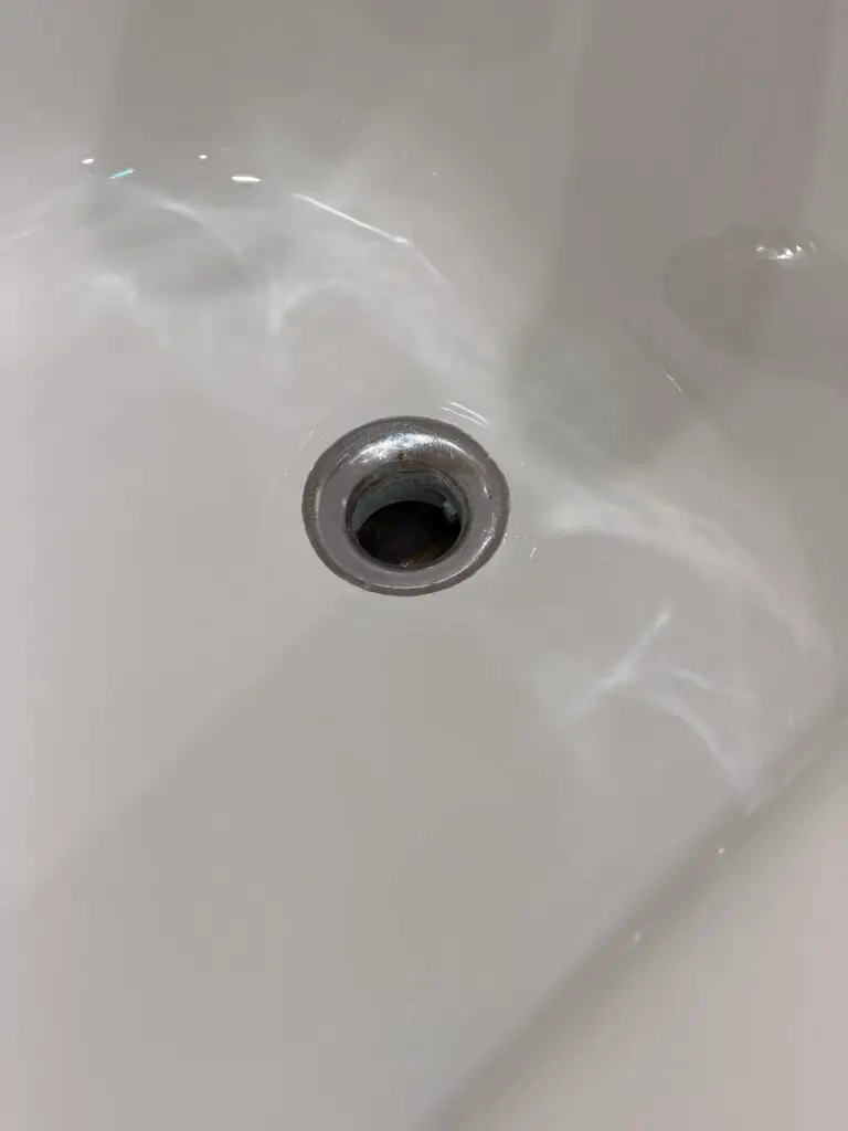 White bathtub surface around the drain after refinishing in Lincoln Park, Chicago.