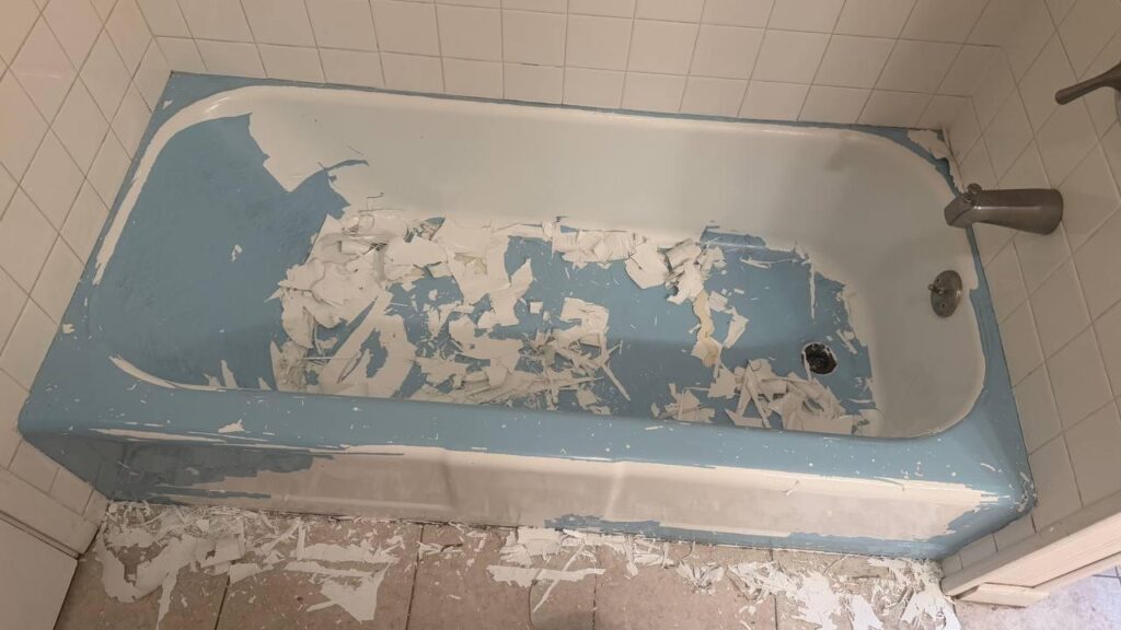 White coating being removed from a blue bathtub in a Downers Grove, IL home.